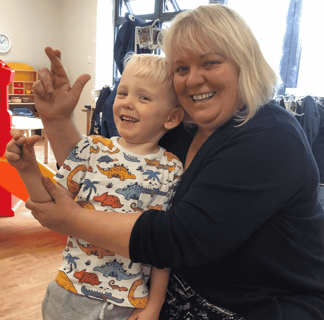 Adult and child practising crossing fingers - nursery