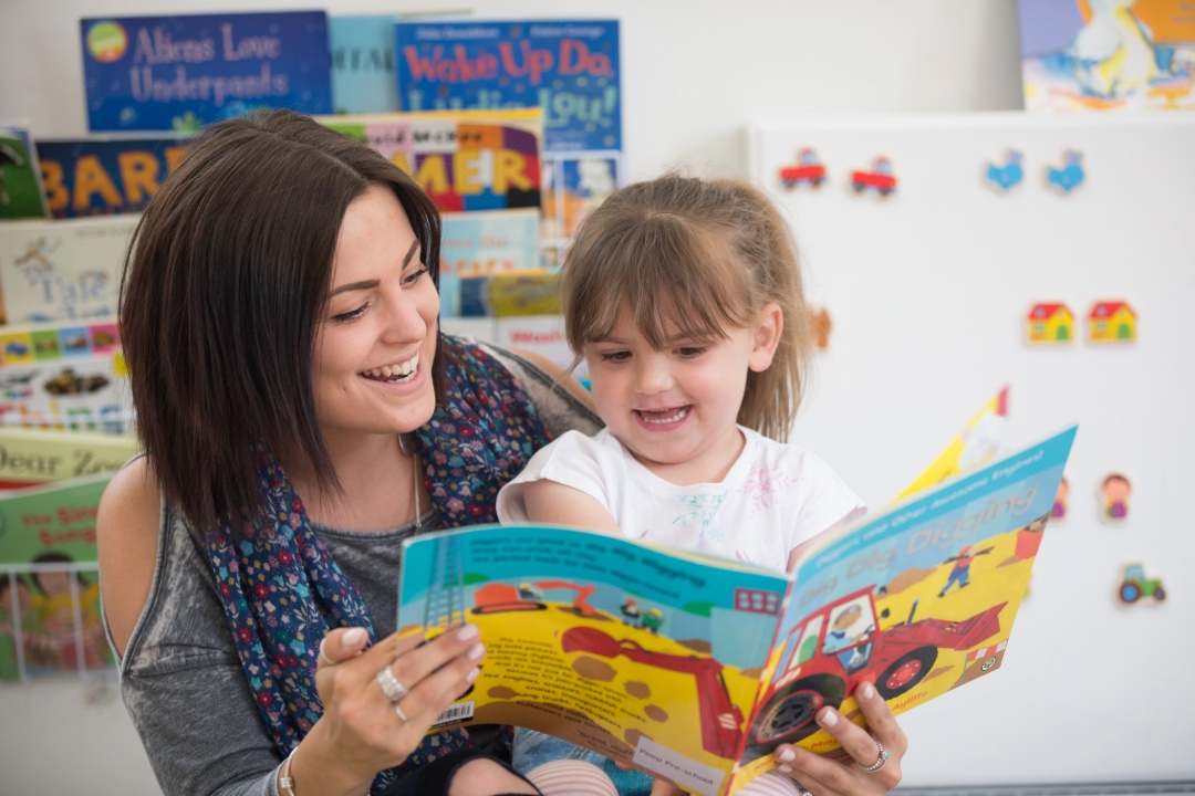 Adult and young child sharing a book